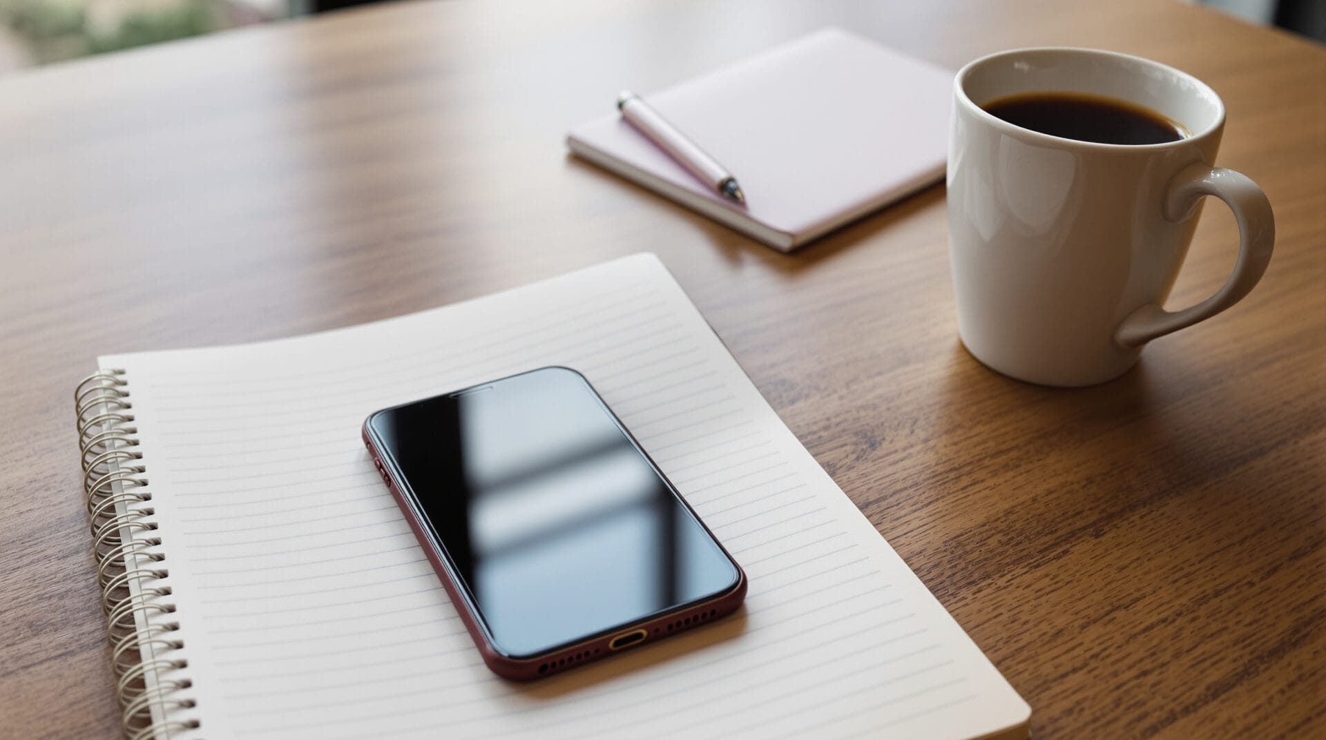 Smartphone and notebook on a quiet cafe table illustrating AI agent privacy